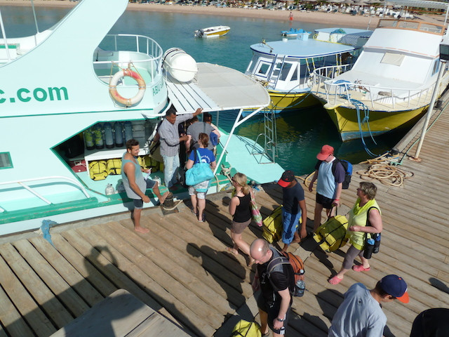 Taucher gehen auf ein Boot